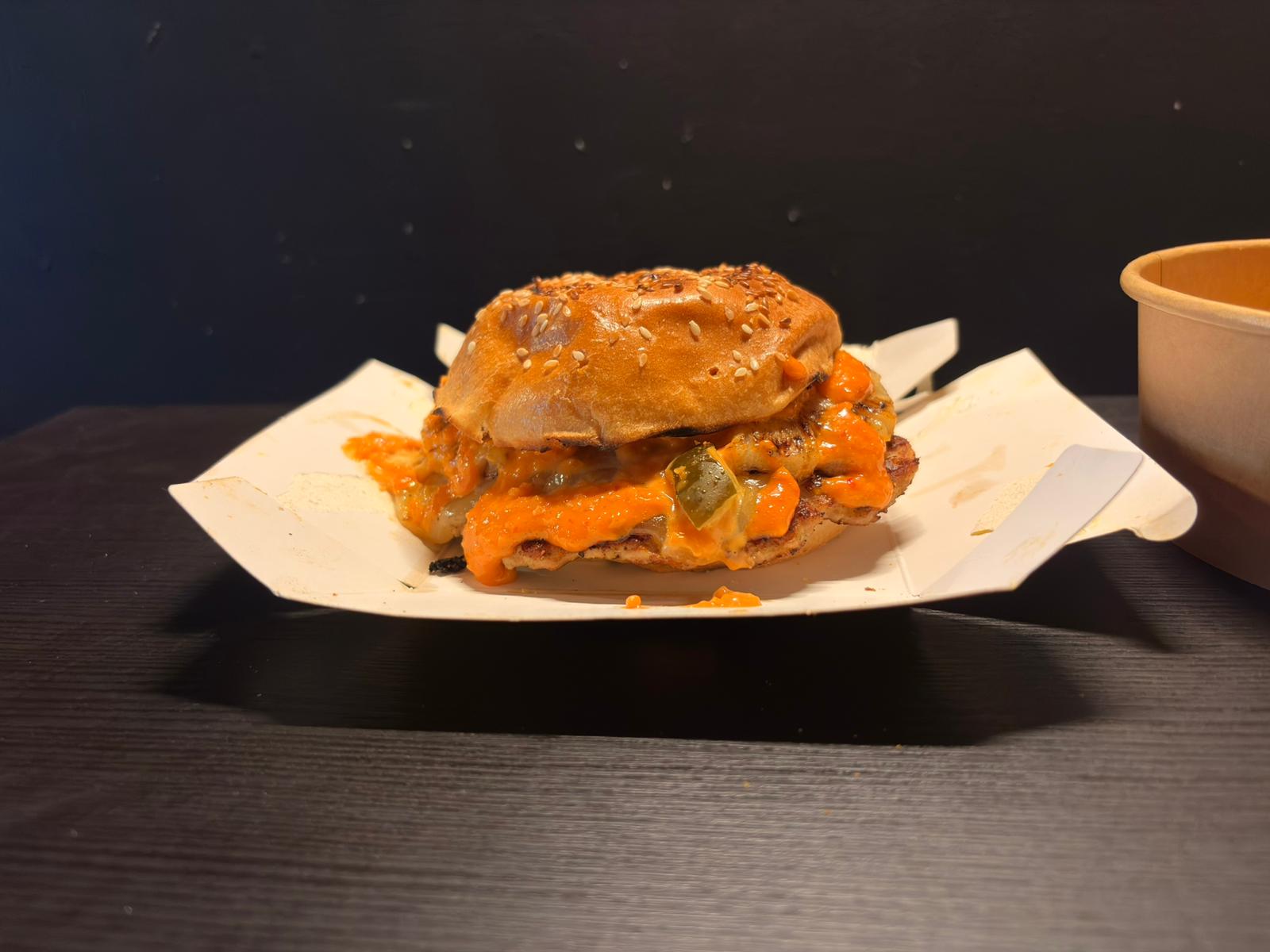 Hand-smashed beef patty with a golden crust, topped with melted cheese, fresh toppings, and our house Algerian sauce.