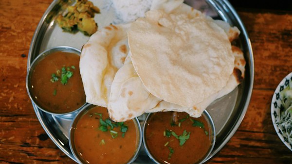 traditional indian thali, a large circular stainless steel platter containing a complete, balanced meal of various dishes