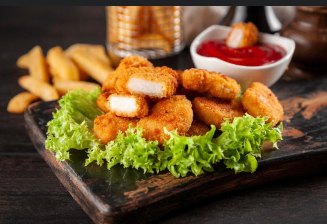 chicken nuggets served on a bed of fresh lettuce,with ketchup