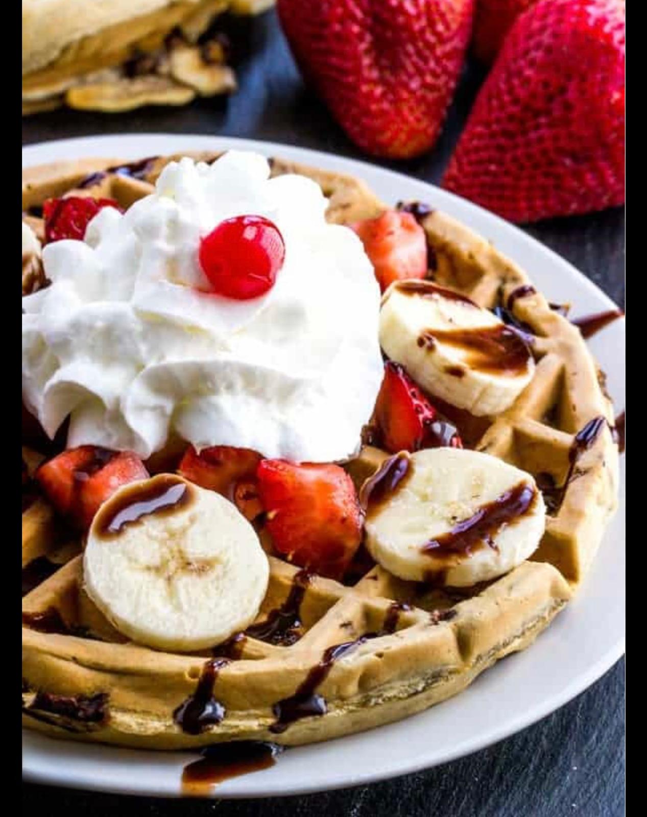Delicious crepes with Strawberry pieces, banana pieces chocolate syrup and powdered sugar, with whipped cream on top 