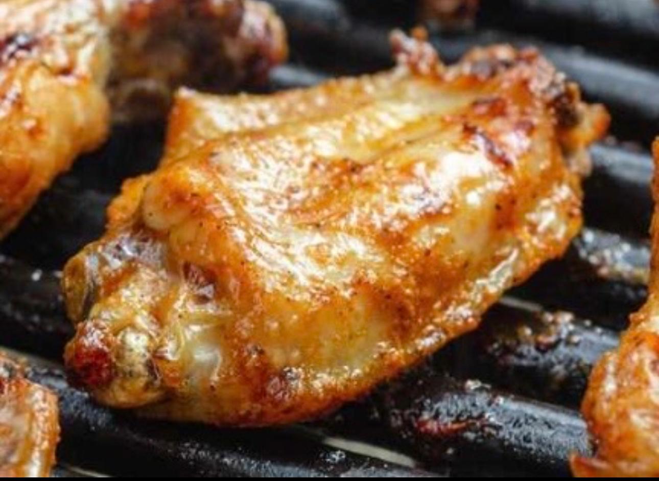 chicken wings on a grill, being nicely cooked