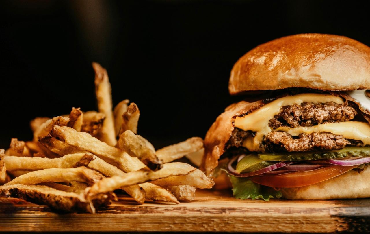 fantastic looking  triple stacker burger, with chese, tomato and bacon