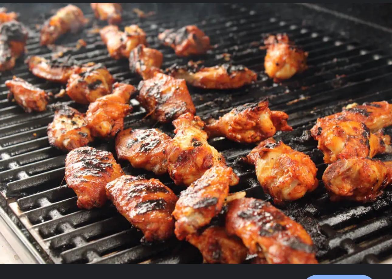 chicken wings on a grill, being nicely cooked, showing barbecue sauce on them, 
