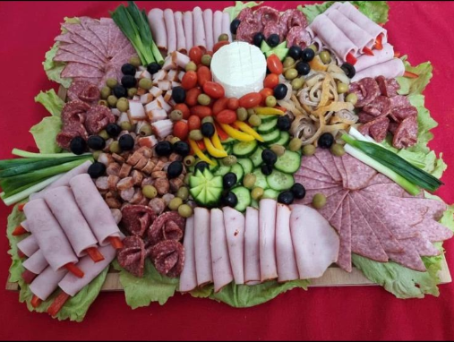 huge platter full of several types of ham, olives, cucumber, peppers, made to share.