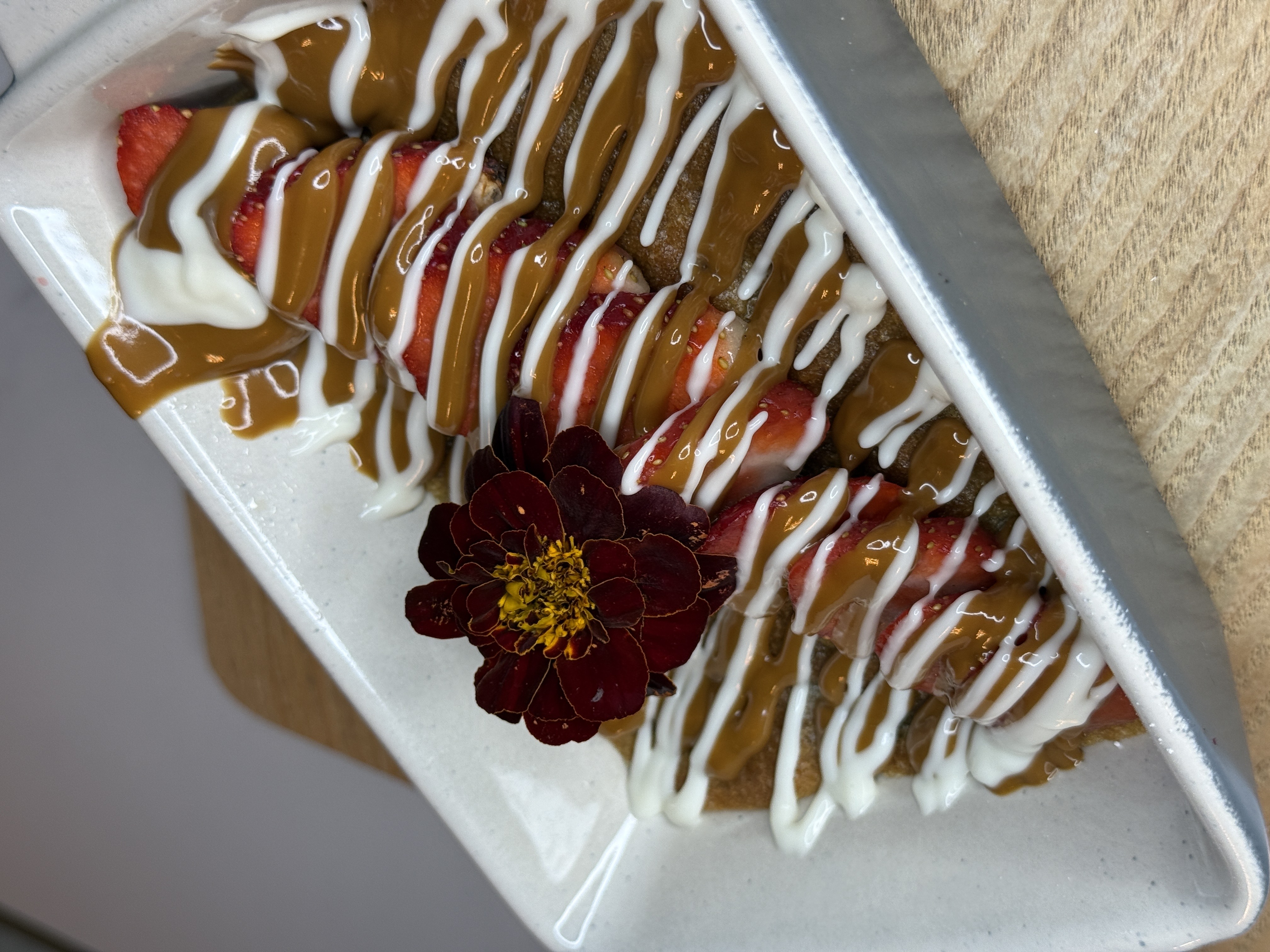 Warm gooey Cookie dough with lotus and white sauce topped with fresh Strawberries.