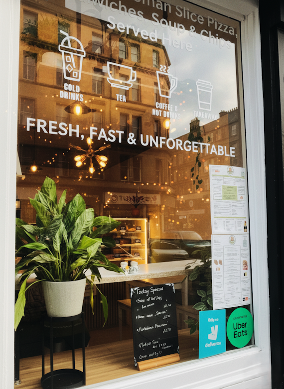 "Al Taglio Edinburgh pizza shop window featuring 'Fresh, Fast & Unforgettable' branding and artisan cafe atmosphere.