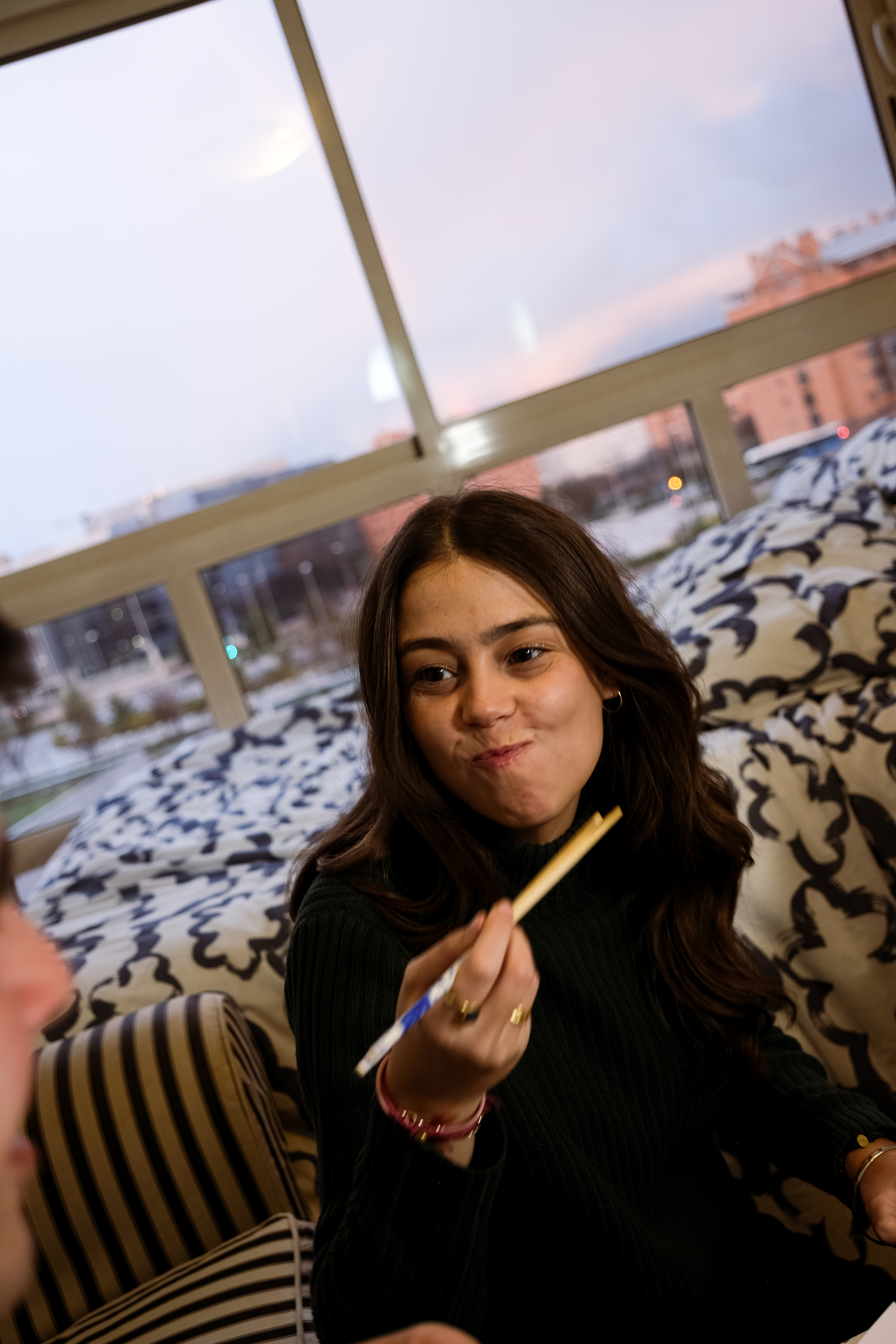 Mujer comiendo sushi nikkei delivery en casa en madrid.