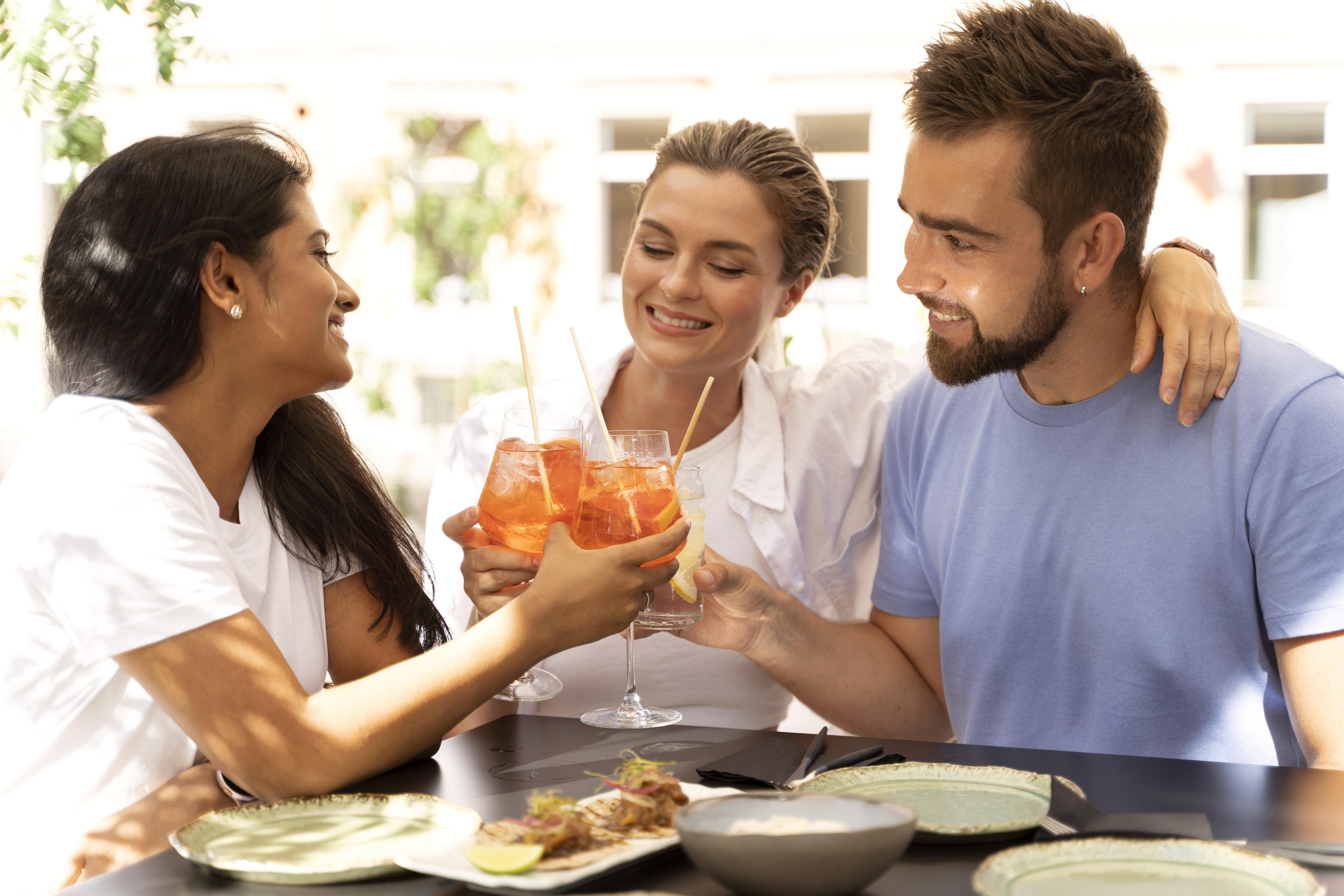 Trois personnes levant un verre à l'amitié et la convivialité grâce à une livraison Apéro Minute