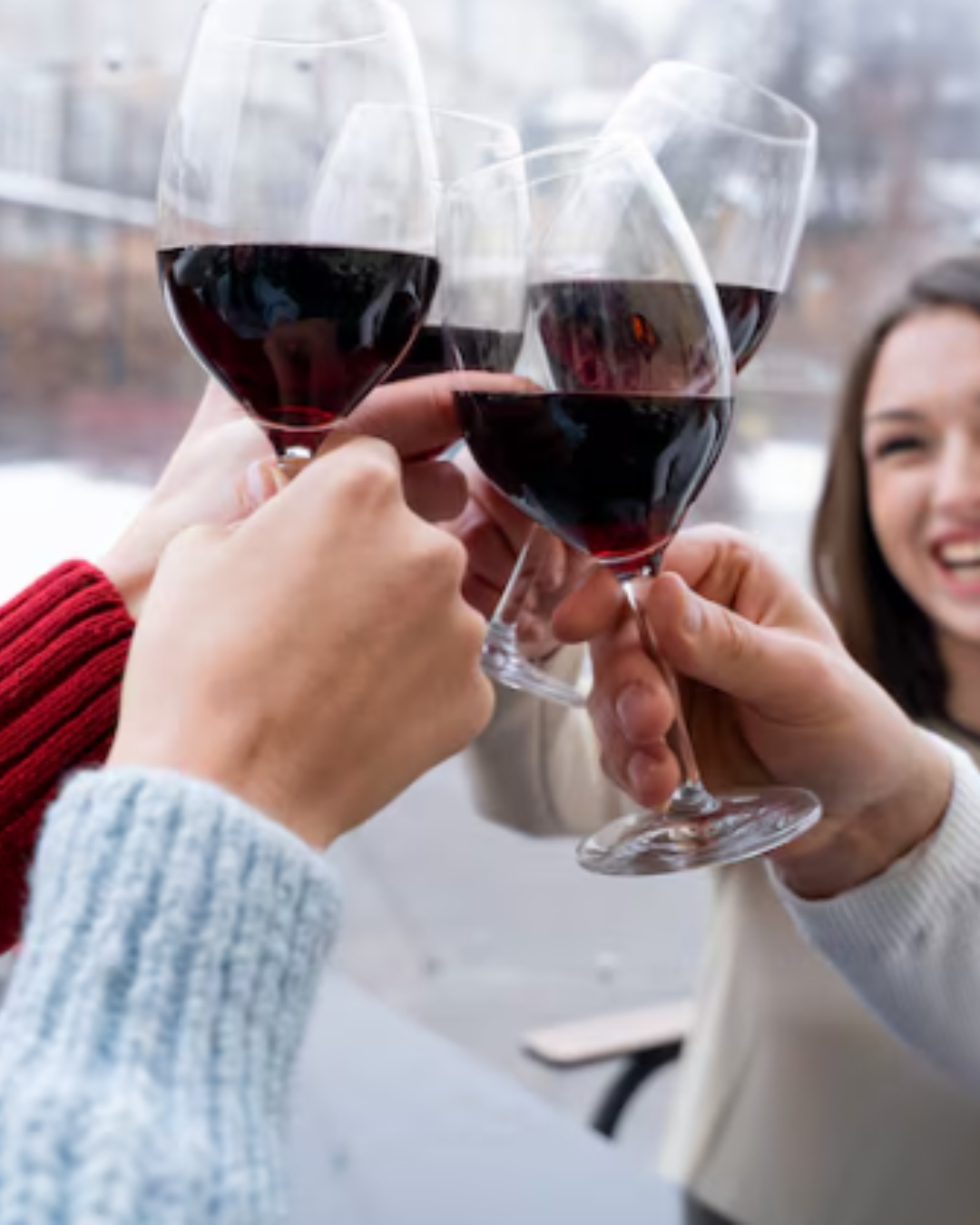 Des personnes qui lèvent leur verre sous la neige à Rennes. C'est du vin rouge.