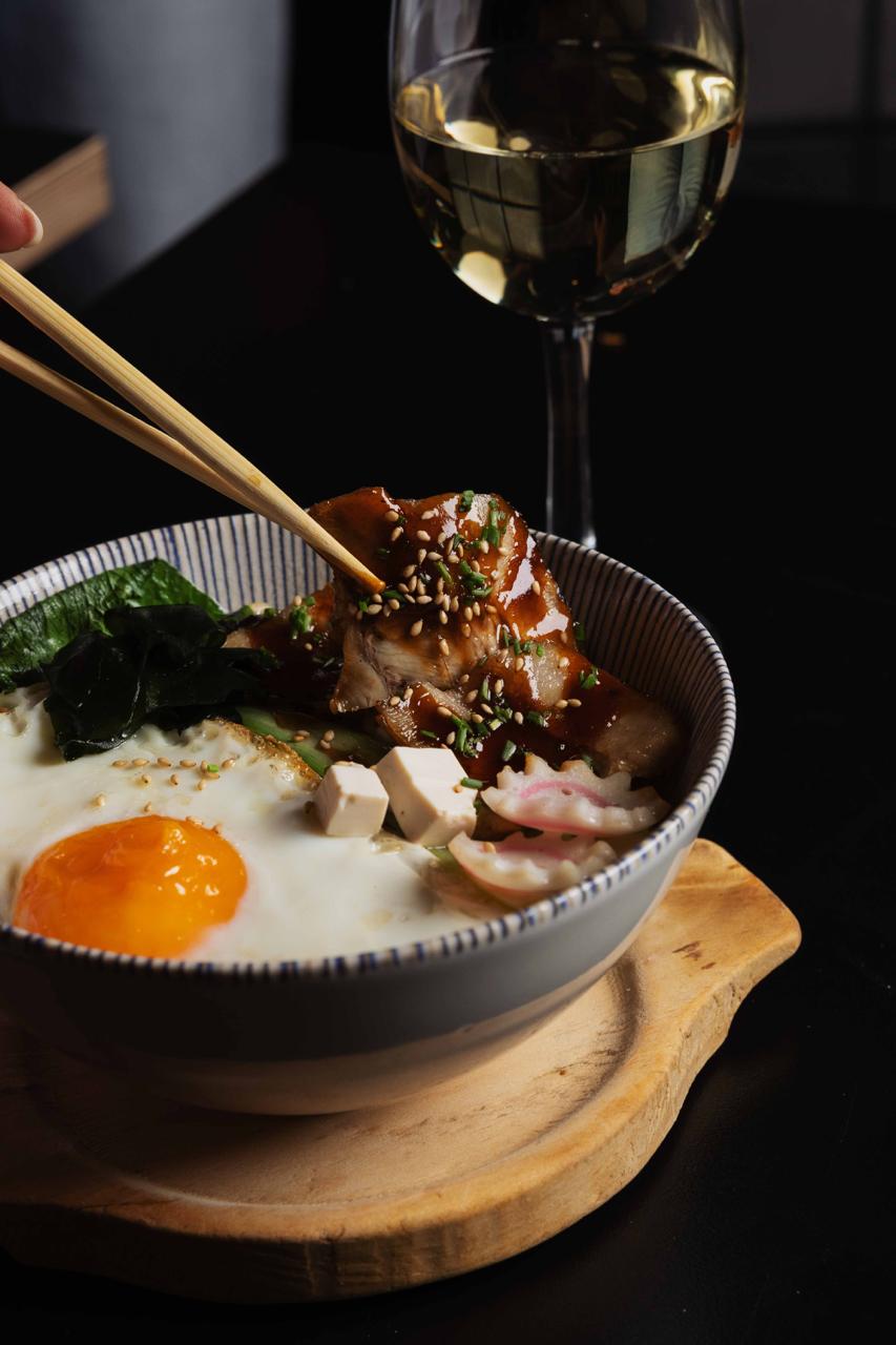 Caldo humeante con chashu, huevo a la plancha, tofu y verduras.
