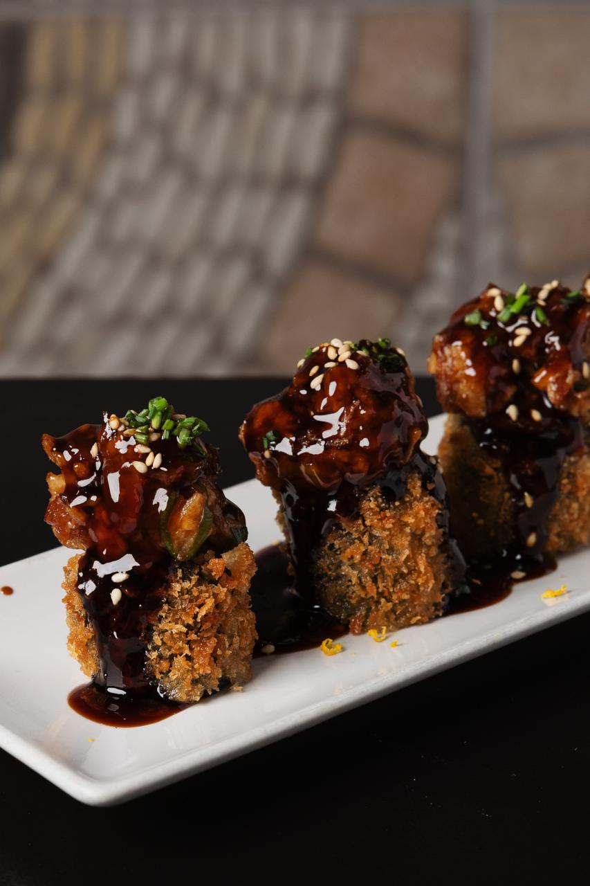 Uramaki rebozado, coronado con salsa teriyaki y sésamo tostado. Especialidad de Koikoi Barcelona.