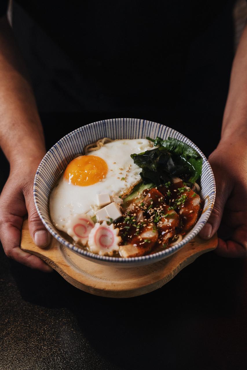 Detalle de chashu con semillas de sésamo y caldo intenso.