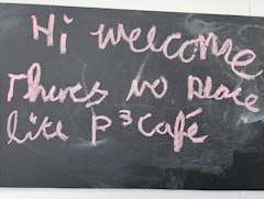 Blackboard with pink writing. "Hi welcome there's no place like P³ Café" as reviewed by Lauren 