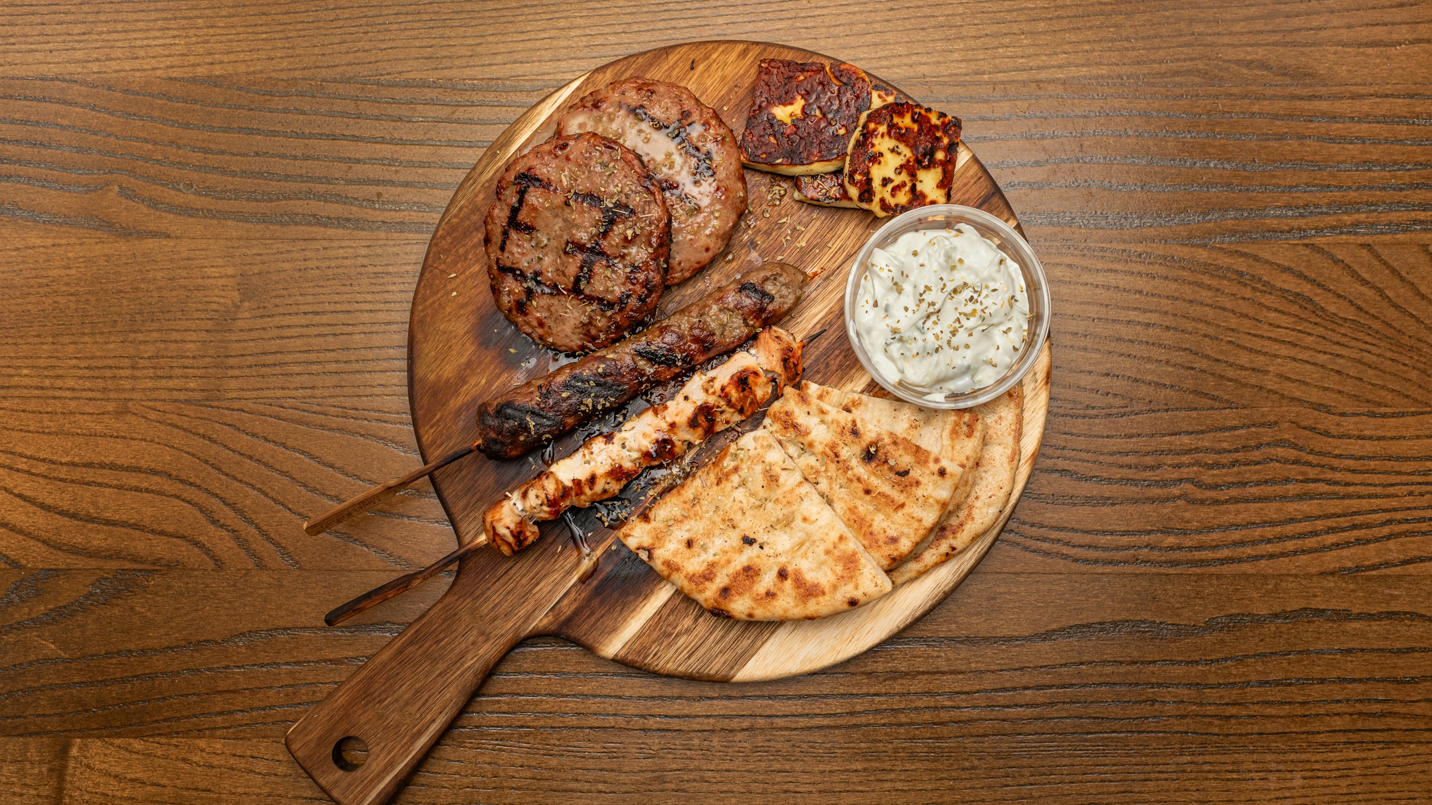 Mixed grill for one, featuring greek kebab, skewer, tzatziki and pita bread.