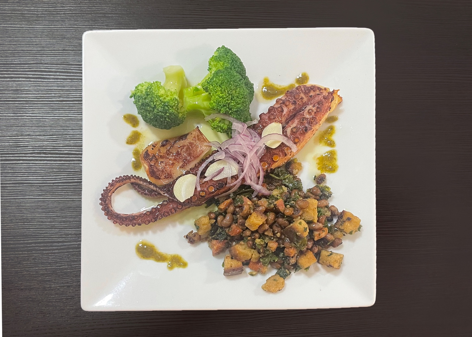 Octopus with chorizo, cornbread crumbs, black-eyed peas and vegetables.